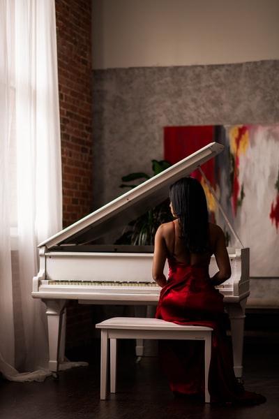 女人红裙子坐在钢琴
